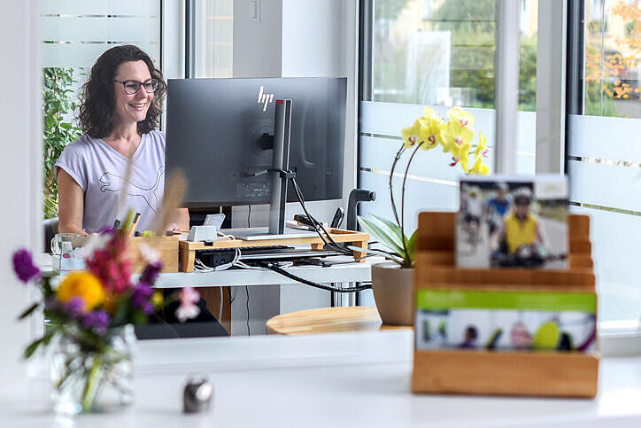 Mitarbeiterin im Physiofit organisiert und prüft Termine am Computer.